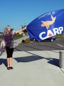 Mary Robertson, chair of CARP’s Greater Bay of Quinte Area branch, raised chapter 39’s flag for Seniors Day at the Quinte Sports and Wellness Centre on Oct. 1.  Photo: Amanda Lorbetski 