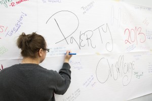 Brandi Belliveau, a first-year student in the Child and Youth Worker program writes down what she learned from the Poverty Challenge on a graffiti wall. Photo by Tyson Leonard.
