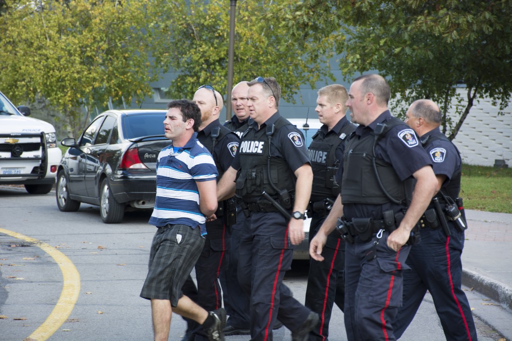 Police take a man into custody following an incident on campus at Loyalist College. Photo by William Acri