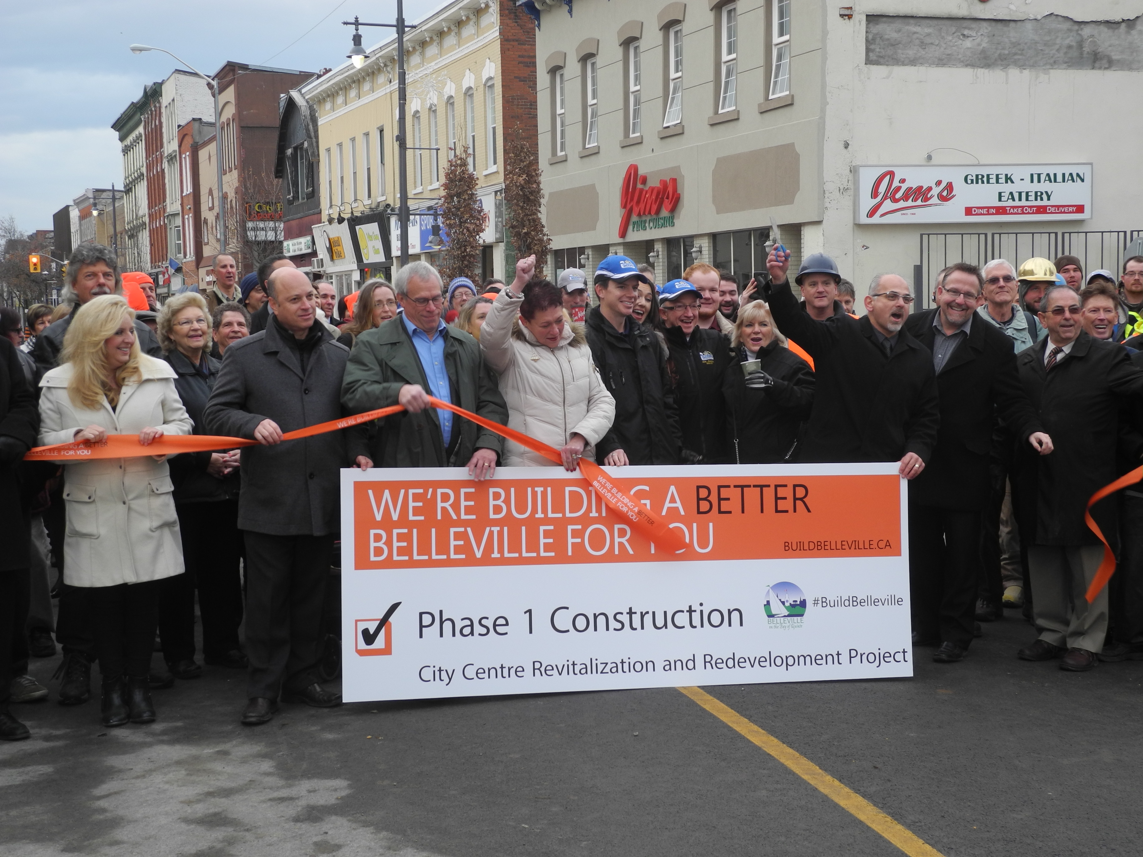 Mayor Taso Christopher (right, with scissors) cuts the ribbon to officially open the first part of the newly-revitalized Front Street. Councillors in the front row, from left: Kelly McCaw, Mitch Panciuk, Jack Miller, Jackie Denyes, Egerton Boyce (right of Christopher) and Garnet Thompson. Photo by Joseph Quigley, QNet News