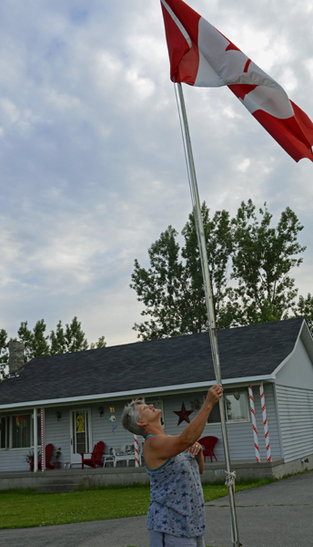 TRENTON ONT (27/06/2011) Trenton resident Rachel Rumbolt adjusts one of her many Canadian Flags. She flies the flag because she loves Canada. She takes a flag everywhere she goes. She recently flew one at a Nascar race in Michigan. She also supports the Canadian military and counts her family as one of "lucky ones" when her brother returned unharmed after two Afghanistan tours.