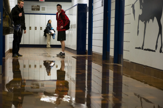 BELLEVILLE, Ont (14/01/13)- Loyalist College students watch as the athletic hallway fills with water coming from the women's change room. Photo by Richard Barclay.