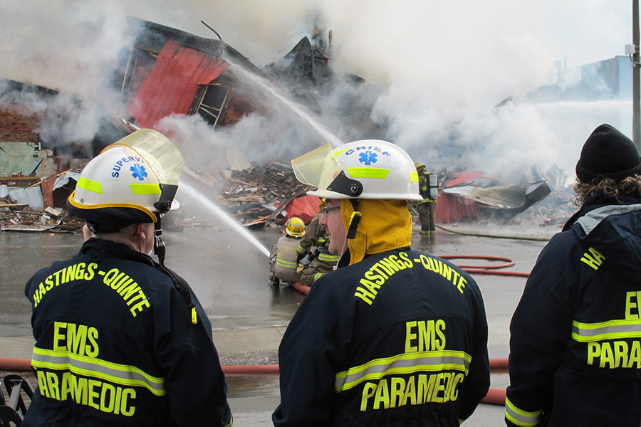 (TRENTON-11/05/2012) Paramedics look on as firefighters battle a blaze at the Sherwood Forest Inn on Monday morning. The building at 19 Murphy Street went up in flames after 9 a.m. Downtown Trenton was blocked off by police and smoke could be seen from Belleville. Photo by Marc Venema.