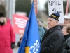 (BELLEVILLE) 11-12-2012 - John Zikopoulos, president of the OSSTF Active Retired Members (ARM) listens intently to Karen Fisk start off Tuesday's rally, bearing a flag that has seen its fair share of political protests. Photo by Keenan Weaver